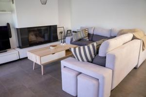 uma sala de estar com um sofá e uma mesa em Olea Residence Palio em PalaiónTsiflíkion
