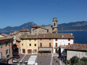 a large building with a clock tower on top of it at Appartamenti Menapace in Torri del Benaco