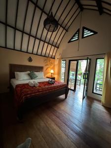 a bedroom with a bed in a room with windows at Gili Land in Gili Air