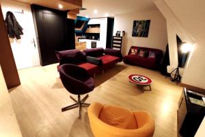 una sala de estar con un sofá y una silla en Le Duplex, Vue Mer et Port, en Saint-Valéry-en-Caux