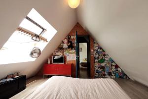 1 dormitorio en el ático con cama y ventana en Le Duplex, Vue Mer et Port, en Saint-Valéry-en-Caux