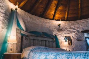 ein Schlafzimmer mit einem Bett in einer Steinmauer in der Unterkunft Anemomylos-Windmill in Ermoupoli