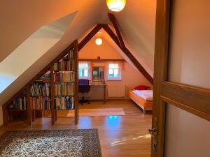 a attic room with a book shelf and a bedroom at Modrá chaloupka in Opařany
