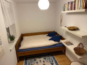 a small bedroom with a bed with blue pillows at Modrá chaloupka in Opařany