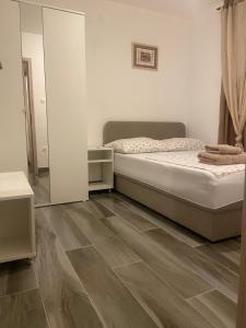 a bedroom with a bed and a mirror at Apartments Simoneta in Malinska