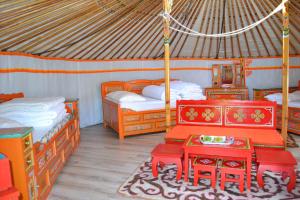 a room with two beds and a table in a yurt at Rando-Yourte in Paluel