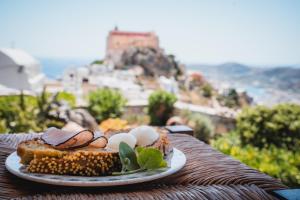 un plato de comida con huevos y pan en una mesa en Anemomylos-Windmill, en Ermoupoli