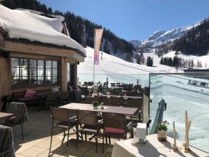 ein Restaurant mit Tischen und Stühlen und eine Skipiste in der Unterkunft Hotel Alpenhof Superior in Zauchensee