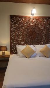 a bedroom with a large bed with a wooden headboard at Wild Cassia in Haputale