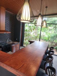 a large wooden table in a kitchen with two lights at Wild Cassia in Haputale