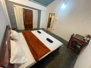 een slaapkamer met een bed met twee blauwe objecten erop bij DA - SAN Stay in Shillong