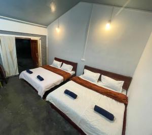 twee bedden in een kleine kamer met twee bedden sidx sidx sidx bij DA - SAN Stay in Shillong