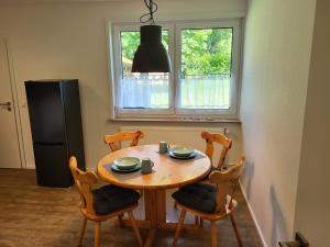 eine Küche mit einem Tisch und Stühlen sowie einem Kühlschrank in der Unterkunft Ferienwohnung am Thonhopsberg in Eimke