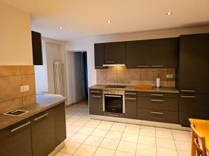 a kitchen with brown cabinets and a stove top oven at Auberge d antan du Lion d Or in Le Locle