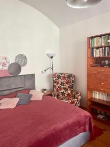 a bedroom with a red bed and a chair at Apartment Ela Centre in Košice