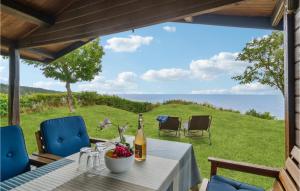 倫訥的住宿－Beach Front Home In Rnne With Wifi，天井上的桌子、一瓶葡萄酒和椅子