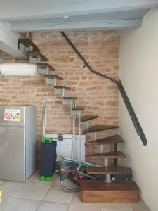 uma escada num quarto com uma parede de tijolos em superbe appartement avec parking à proximité em Sombernon