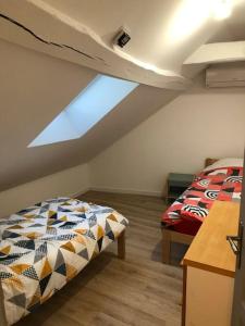um quarto no sótão com 2 camas e uma janela em superbe appartement avec parking à proximité em Sombernon