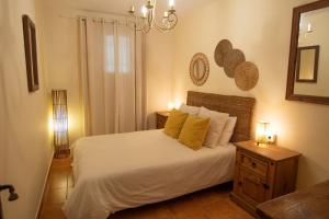 um quarto com uma cama branca e almofadas amarelas em Casa del fuego em Moya