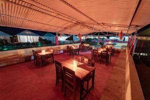 ein Restaurant mit Holztischen und -stühlen mit Lichtern in der Unterkunft Shama Desert Luxury Camp & Resort in Jaisalmer