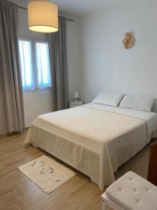 a white bedroom with a large bed and a window at Corte Vettori in Quarrata