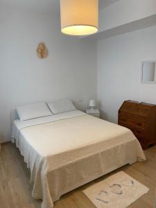 a white bedroom with a bed and a dresser at Corte Vettori in Quarrata