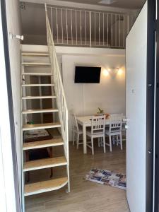 - un escalier dans une pièce avec une table et une salle à manger dans l'établissement Corte Vettori, à Quarrata