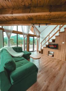 a living room with a green couch and wooden floors at Stuf by NorAtlas Heritage - Adults Only in Buzău