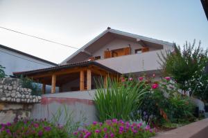 a house with flowers in front of it at Apartmani Dina 1 in Posedarje