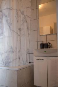 een witte badkamer met een wastafel en een spiegel bij Apartmani Dina 1 in Posedarje