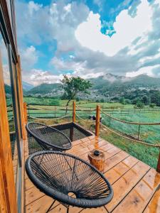 two chairs on a wooden deck with a view of a field at Stuf by NorAtlas Heritage - Adults Only in Buzau