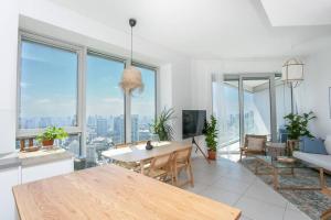 un soggiorno con tavolo e alcune finestre di Luxury 2BR Central TLV Apartment a Tel Aviv