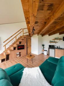 a living room with a green couch and a staircase at Stuf by NorAtlas Heritage - Adults Only in Buzau