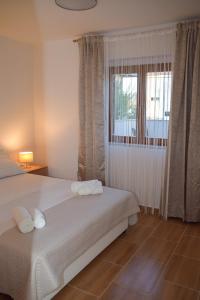 een slaapkamer met twee bedden en een raam bij Apartmani Dina 1 in Posedarje