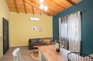 uma sala de estar com um sofá e uma mesa com copos de vinho em Hara Apartments em Chrysoupolis