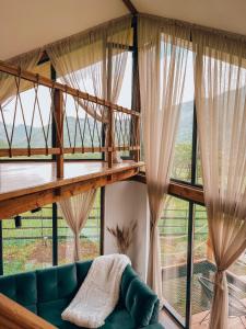Stuf by NorAtlas Heritage - Adults Only في بوزاو: غرفة معيشة مع أريكة خضراء ونوافذ كبيرة