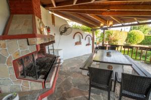 un patio al aire libre con chimenea, mesa y sillas en Hara Apartments en Chrysoupolis