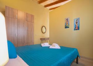 una camera da letto con un letto blu e asciugamani di Hara Apartments a Chrysoupolis
