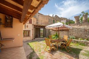 - une table et des chaises avec un parasol dans la cour dans l'établissement Dels BOUS 163 SINEU, à Sineu