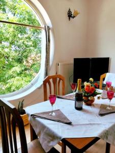 einen Tisch mit einer Flasche Wein und Gläsern darauf in der Unterkunft Serenity's Sunset Terrace in Shkodra