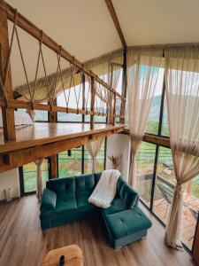 a living room with a green couch and a large window at Stuf by NorAtlas Heritage - Adults Only in Buzău