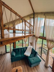 ein Wohnzimmer mit einem grünen Sofa und einem großen Fenster in der Unterkunft Stuf by NorAtlas Heritage - Adults Only in Buzău