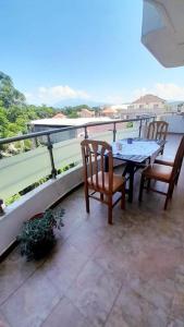 eine Terrasse mit einem Tisch und Stühlen auf dem Balkon in der Unterkunft Serenity's Sunset Terrace in Shkodra