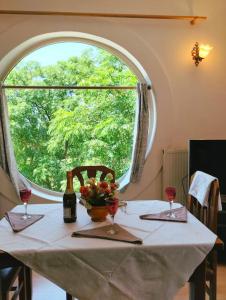 einen Tisch mit zwei Weingläsern und einem großen Fenster in der Unterkunft Serenity's Sunset Terrace in Shkodra