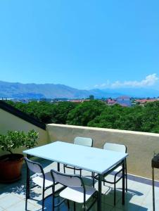 una mesa azul y sillas en el balcón en Serenity's Sunset Terrace, en Shkodër