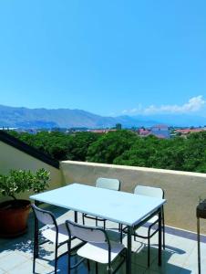 a blue table and chairs on a balcony at Serenity's Sunset Terrace in Shkodër