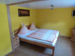 ein Schlafzimmer mit einem Bett in einem Zimmer mit gelben Wänden in der Unterkunft Privatzimmer Rethaber in Ringsheim