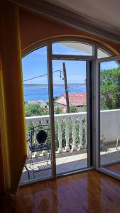 an open door to a balcony with a view of the ocean at Apartments Veni Up in Starigrad