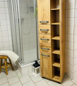 a wooden cabinet in a bathroom with a shower at die perfekte Auszeit in Illingen