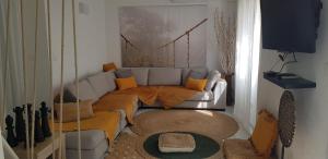 salon z kanapą i telewizorem w obiekcie Koukie Family House w mieście Le Grau-dʼAgde